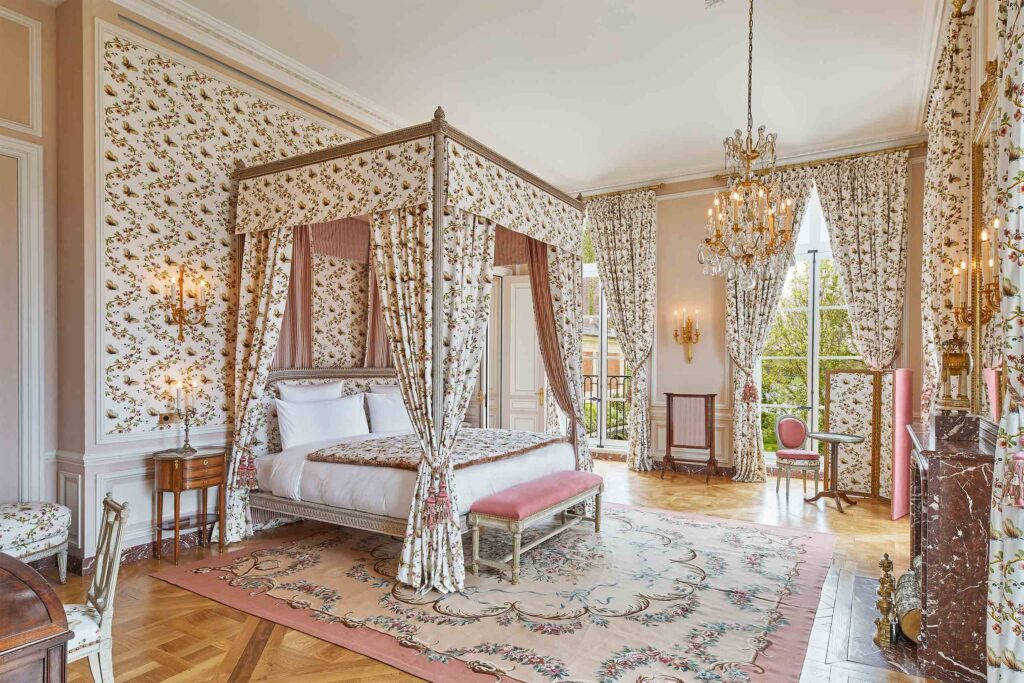 A Parisian chic bedroom with patterned walls at Airelles Château de Versailles.
