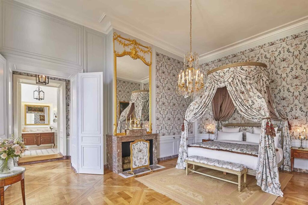 A Parisian chic bedroom with patterned walls at Airelles Château de Versailles.