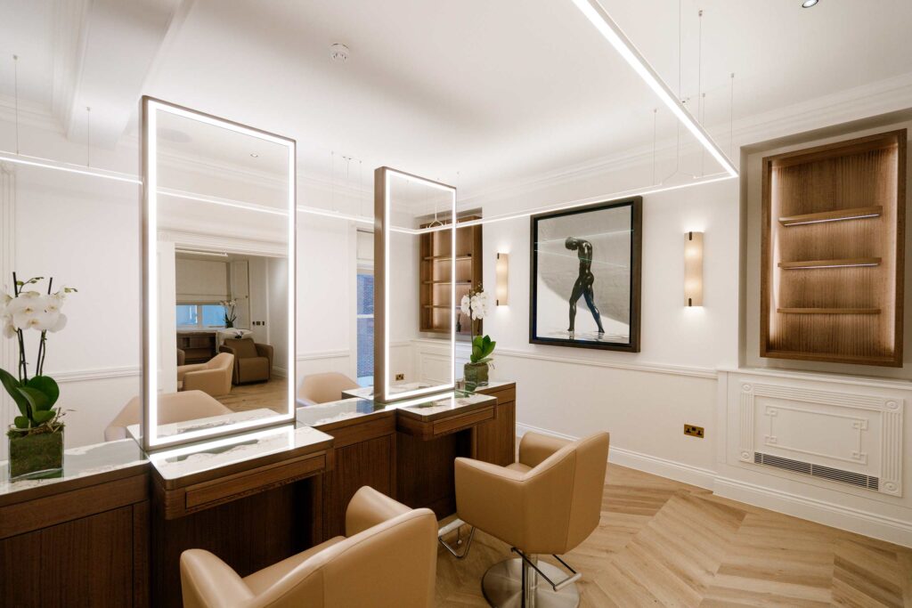 Two leather chairs fronted by illuminated mirrors at The Six hair salon in Mayfair, London. A haircut here belongs on any experiential gift guide
