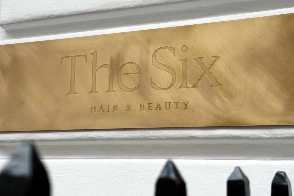 A golden The Six sign outside The Six salon in Mayfair, London. A haircut here belongs on any experiential gift guide