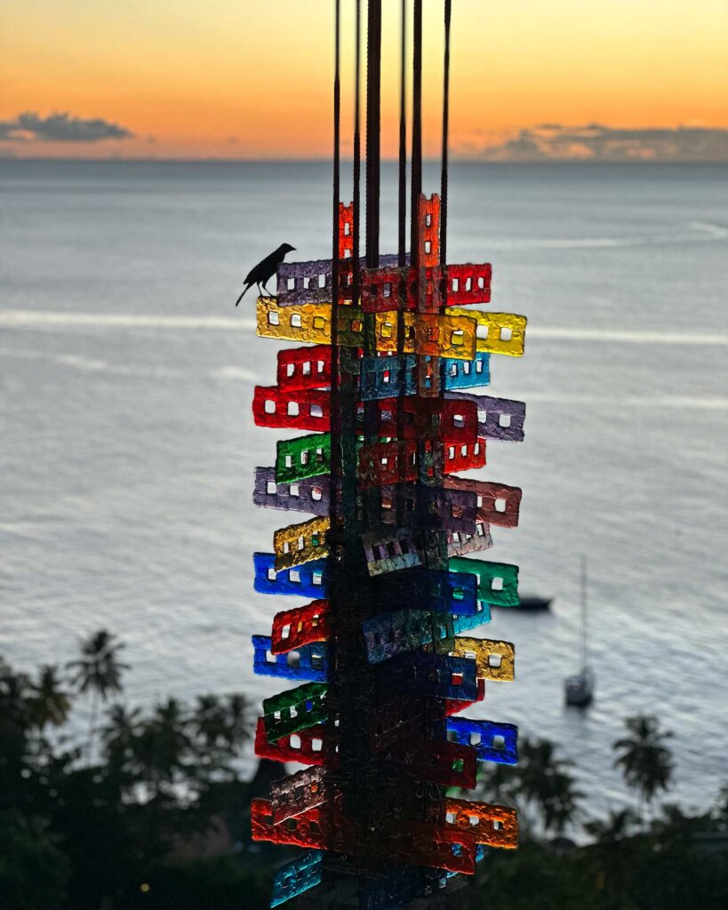 A bird sits on an outdoor artwork during sunset at Jade Mountain, Soufriere, St Lucia