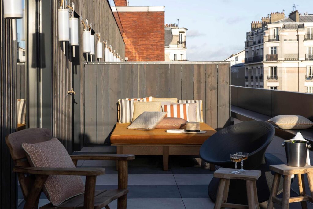 Room terrace lounge area at Mob House with an orange sofa at its centre.