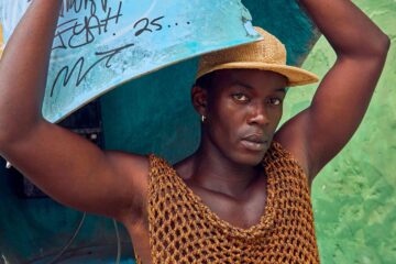 Model Fah Sampaio in yellow hat and mesh vest for OutThere the Salvador Rising Issue