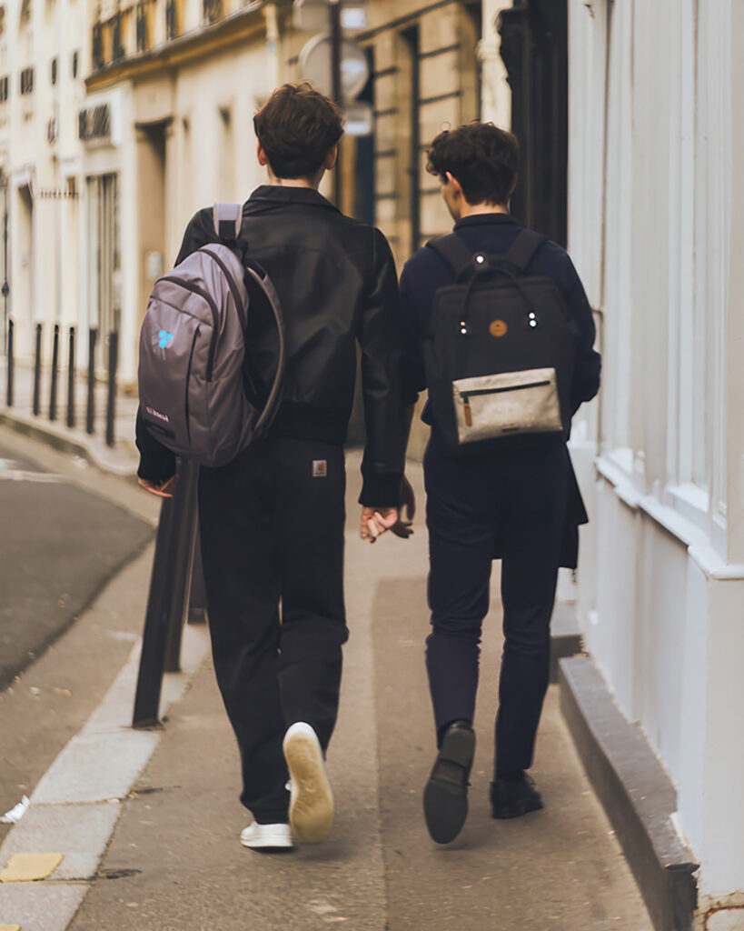 Two young men walk alongside one another in the streets, one of many postcards from Paris, France