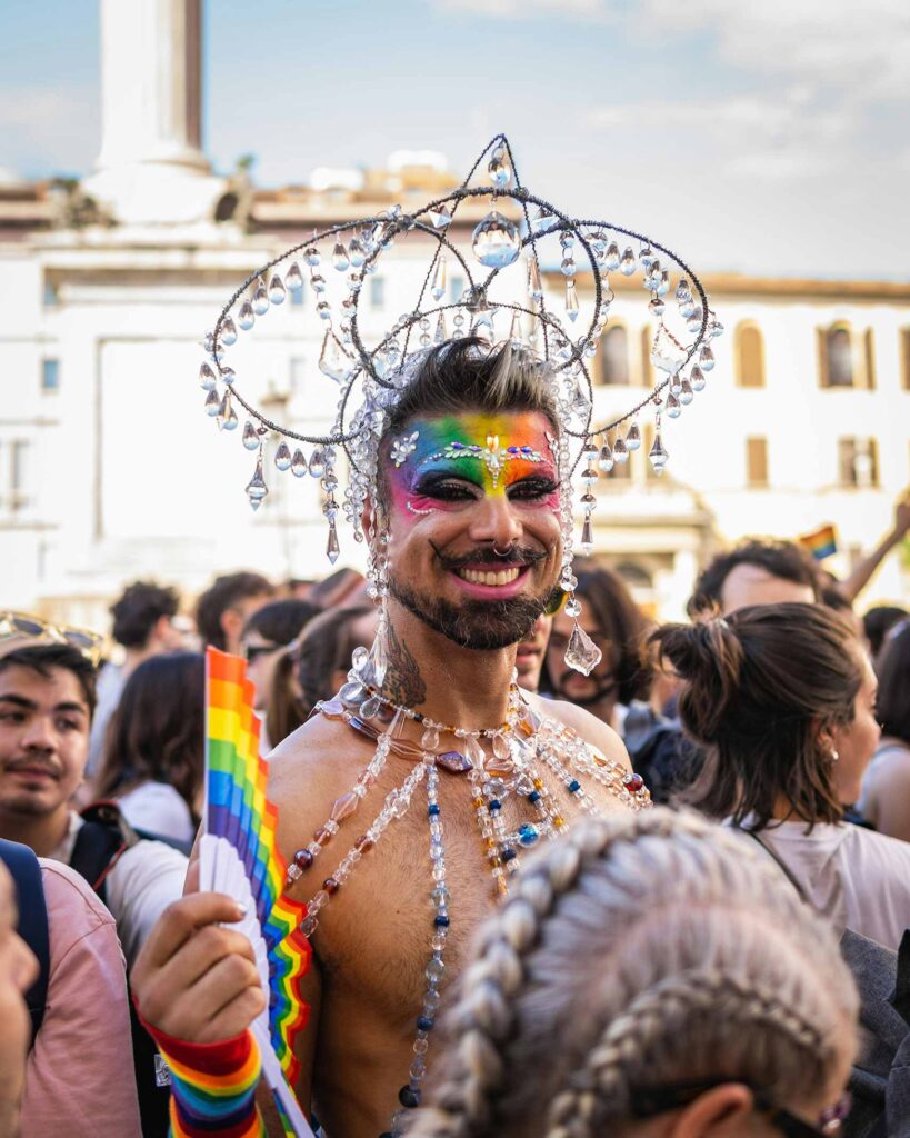 Man in makeup dressed in a costume adorned with crystal like beads