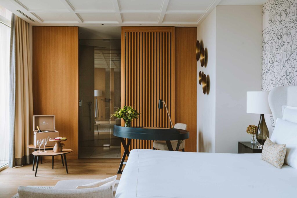 A mid-century-modern-style bedroom with a wooden wall at the Royal Champagne Hotel & Spa.