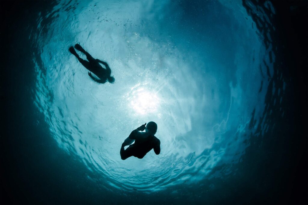 Two visitors snorkel in the Arctic during an expedition